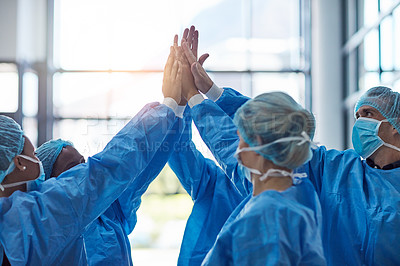 Buy stock photo Cropped shot of a team of medical practitioners high fiving together in a hospital