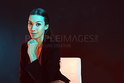 Buy stock photo Portrait of a young businesswoman posing against a dark background