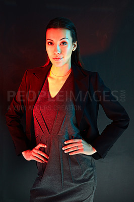 Buy stock photo Portrait of a young businesswoman posing against a dark background