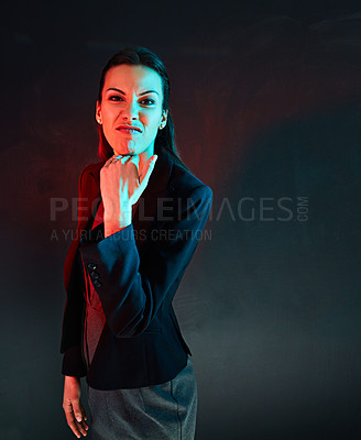 Buy stock photo Portrait of a businesswoman making a rude gesture against a dark background