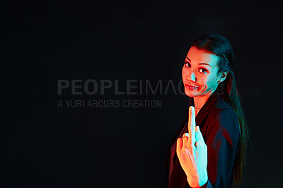 Buy stock photo Portrait of a rude businesswoman showing her middle finger against a dark background