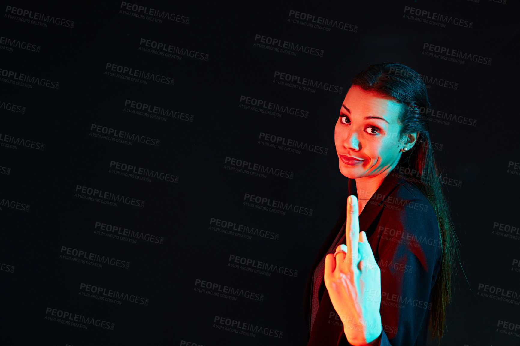 Buy stock photo Portrait of a rude businesswoman showing her middle finger against a dark background