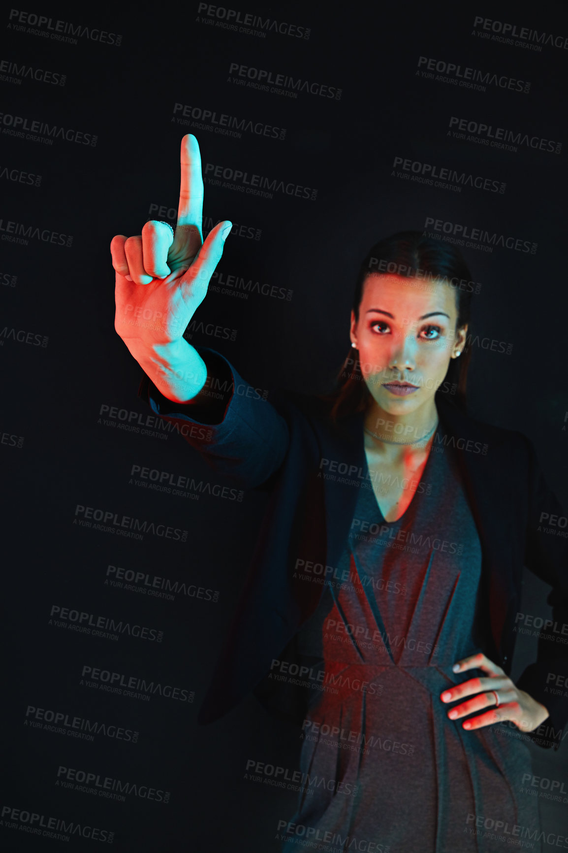 Buy stock photo Portrait of a young businesswoman showing a number with her fingers against a dark background