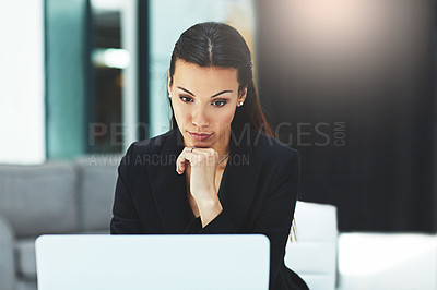 Buy stock photo Shot of a focussed young businesswoman working on her laptop in the office