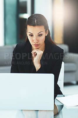 Buy stock photo Shot of a focussed young businesswoman working on her laptop in the office