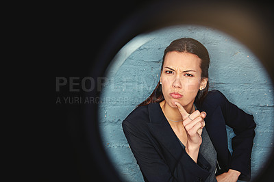 Buy stock photo Portrait of a businesswoman posing against a brick wall with a peephole effect