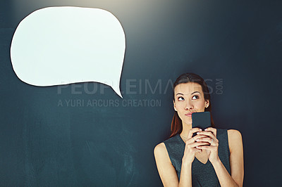 Buy stock photo Shot of a young woman sending a text message against a gray background