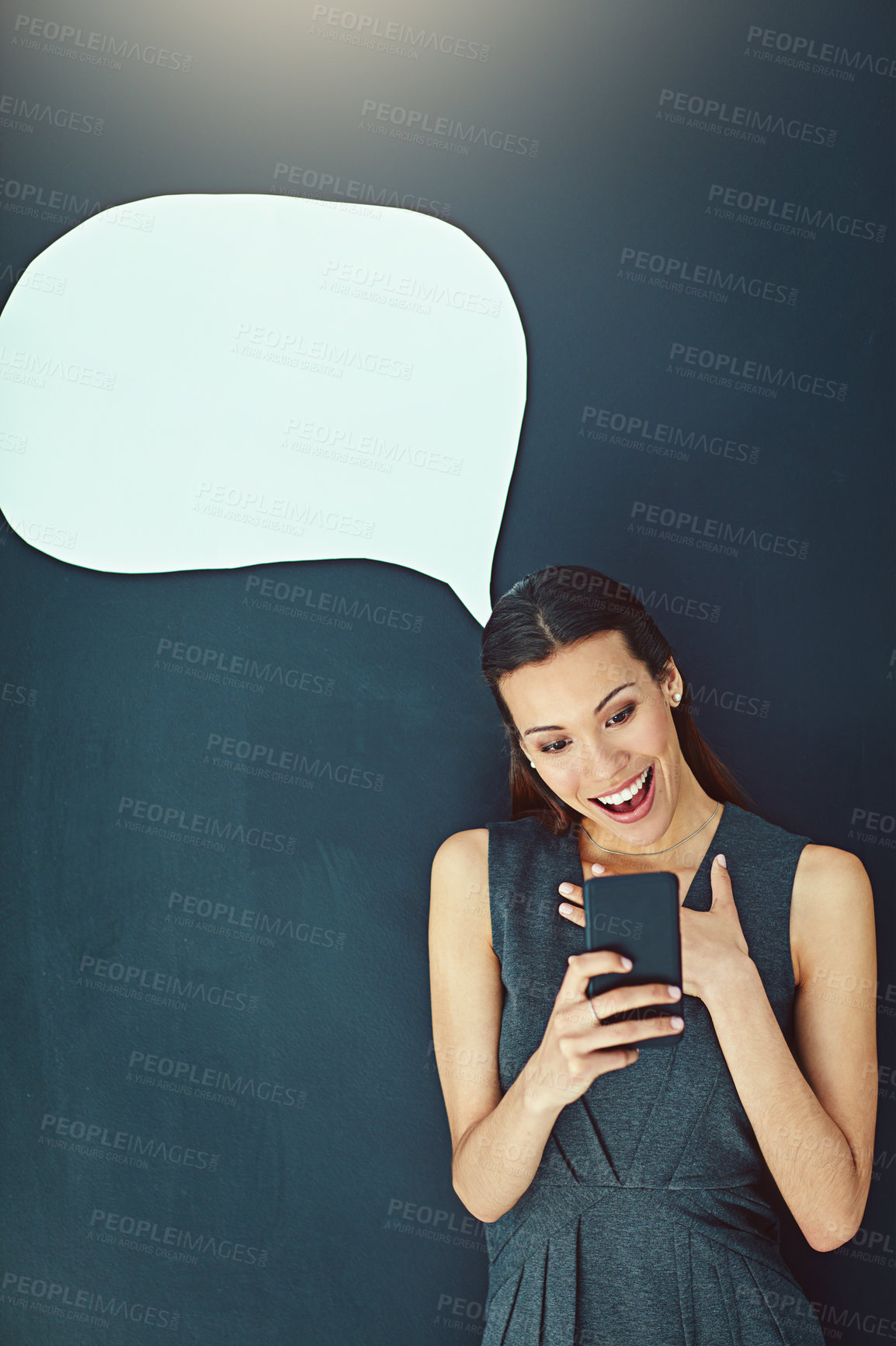 Buy stock photo Shot of a young woman sending a text message against a gray background