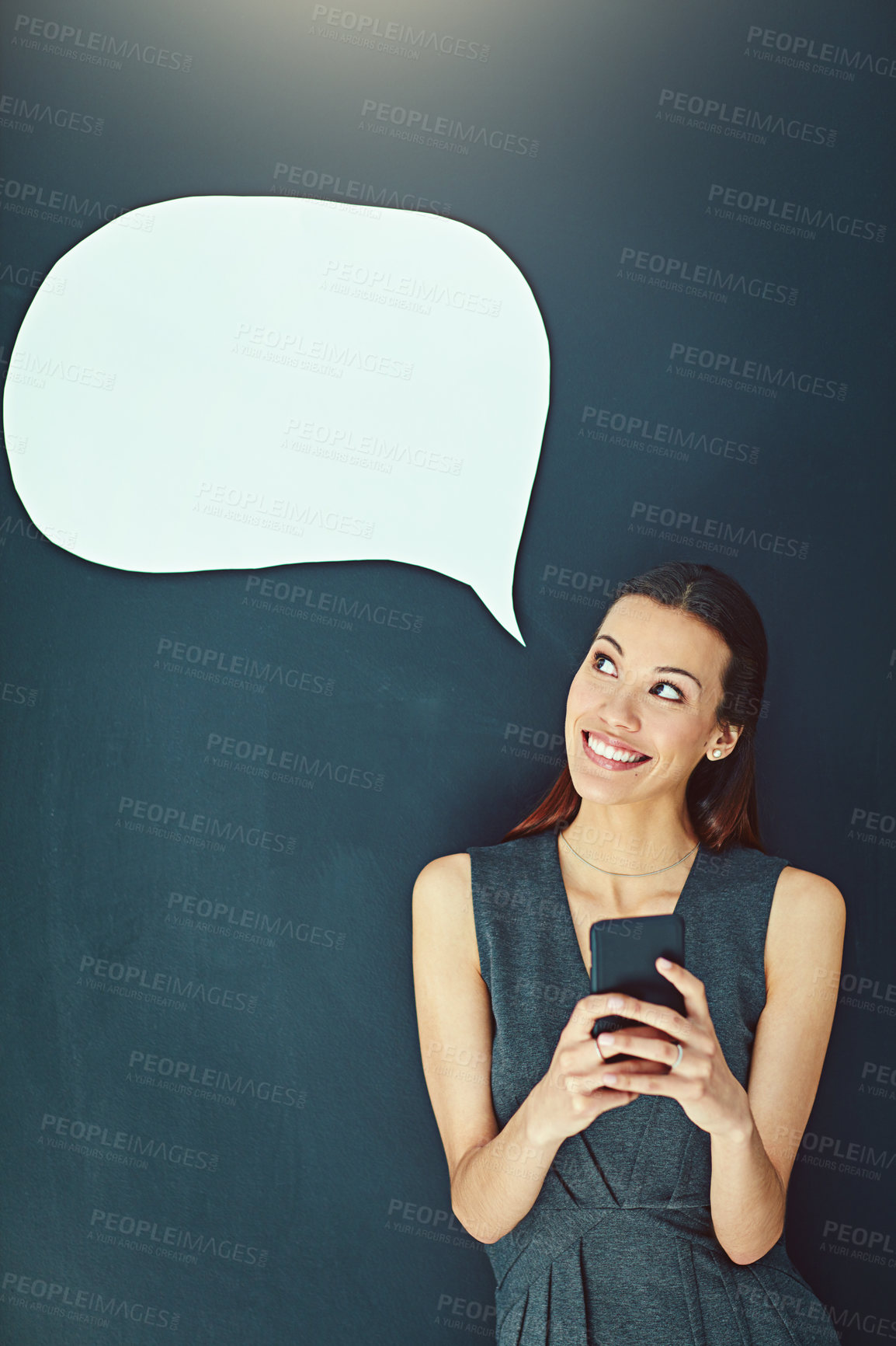 Buy stock photo Shot of a young woman sending a text message against a gray background