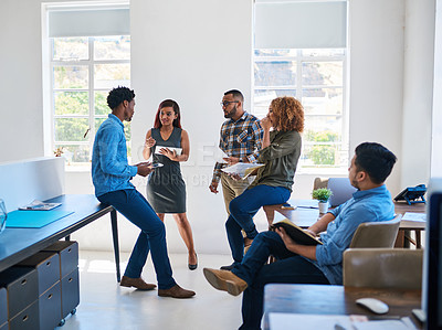 Buy stock photo Shot of a team of young entrepreneurs having a discussion in a modern office