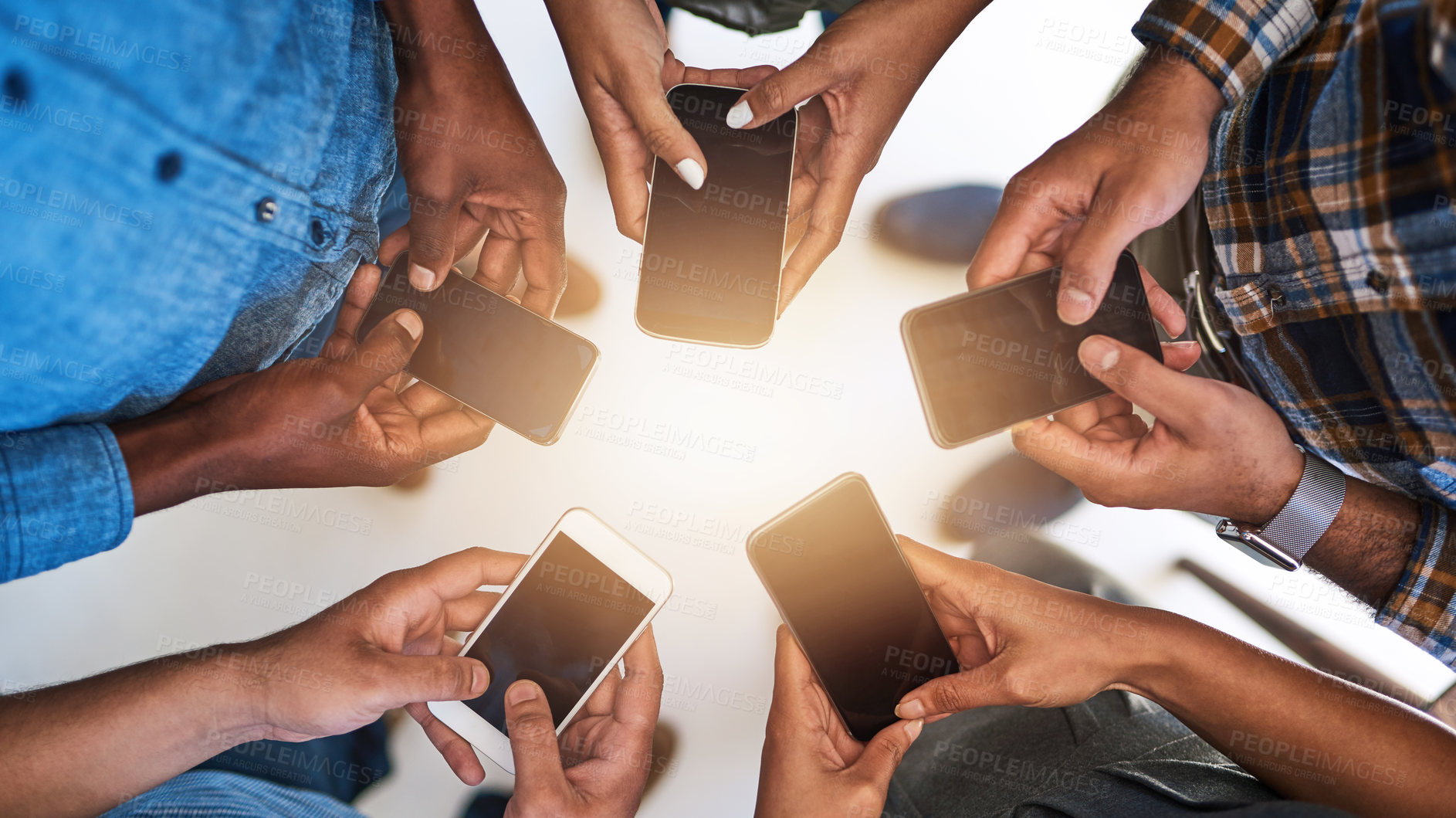 Buy stock photo Cropped shot of a group of people using their smart phones in synchronicity