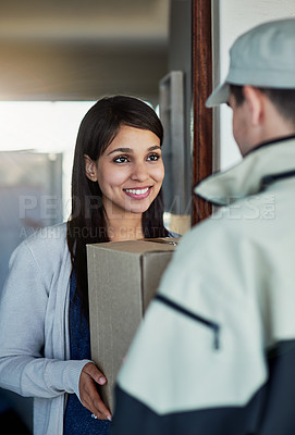 Buy stock photo Cropped shot of a young woman receiving her package from the courier