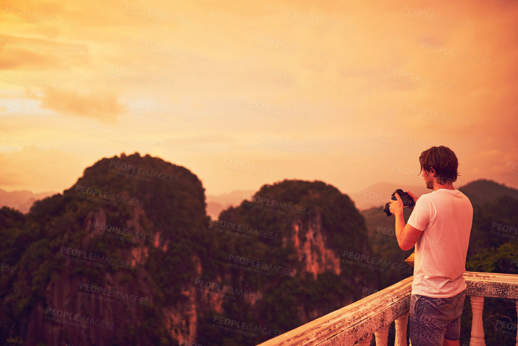 Buy stock photo Cropped shot of a young man taking photos of a scenic view