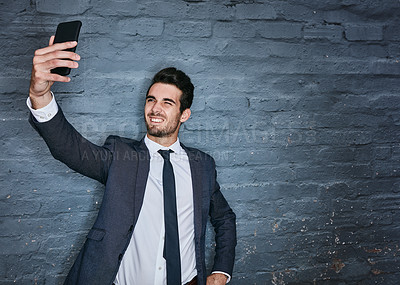 Buy stock photo Shot of a businessman taking a selfie against a grey wall