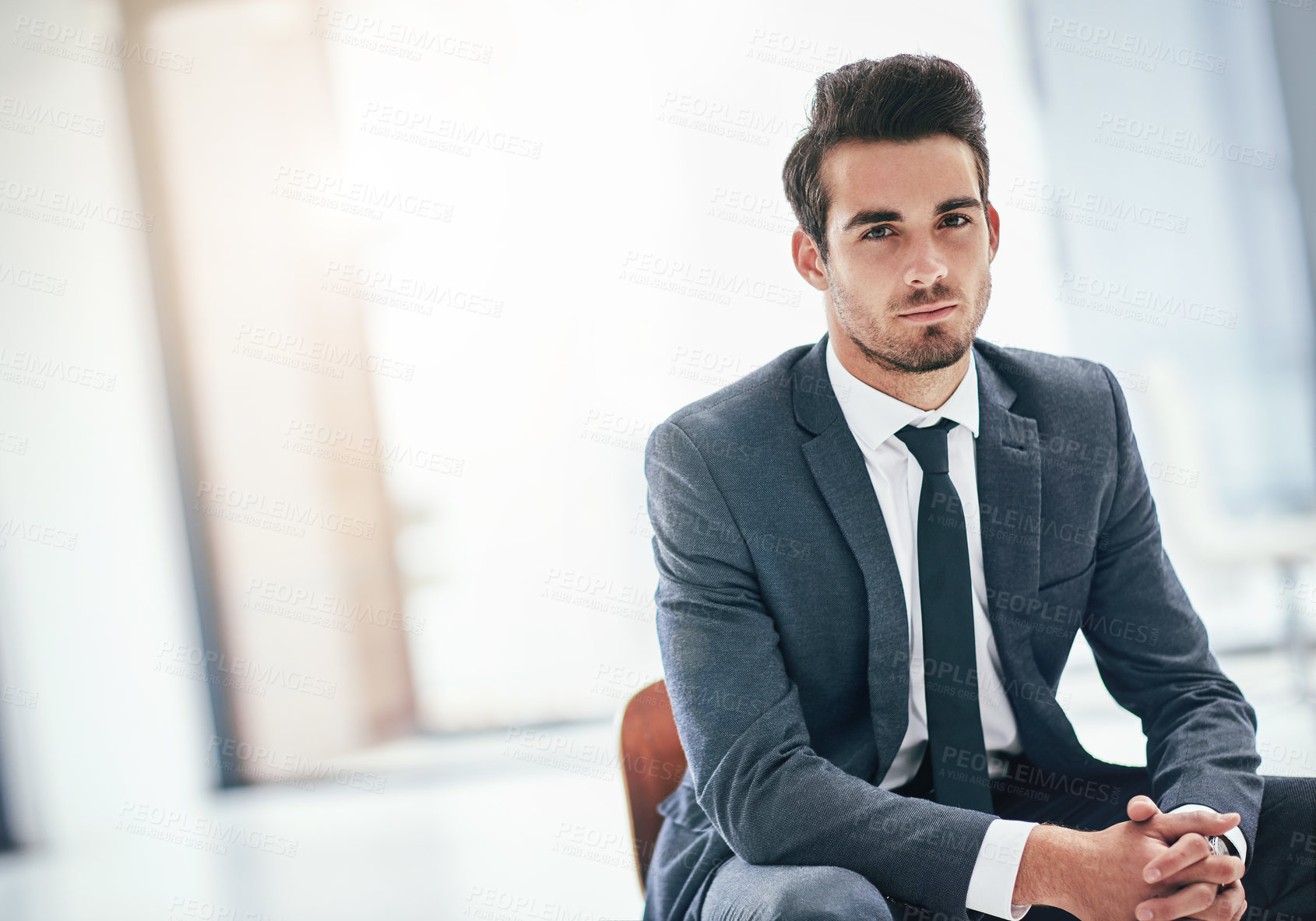 Buy stock photo Portrait of a serious young businessman posing in the office