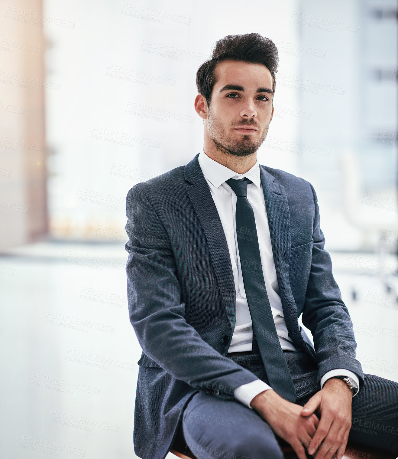 Buy stock photo Portrait of a serious young businessman posing in the office