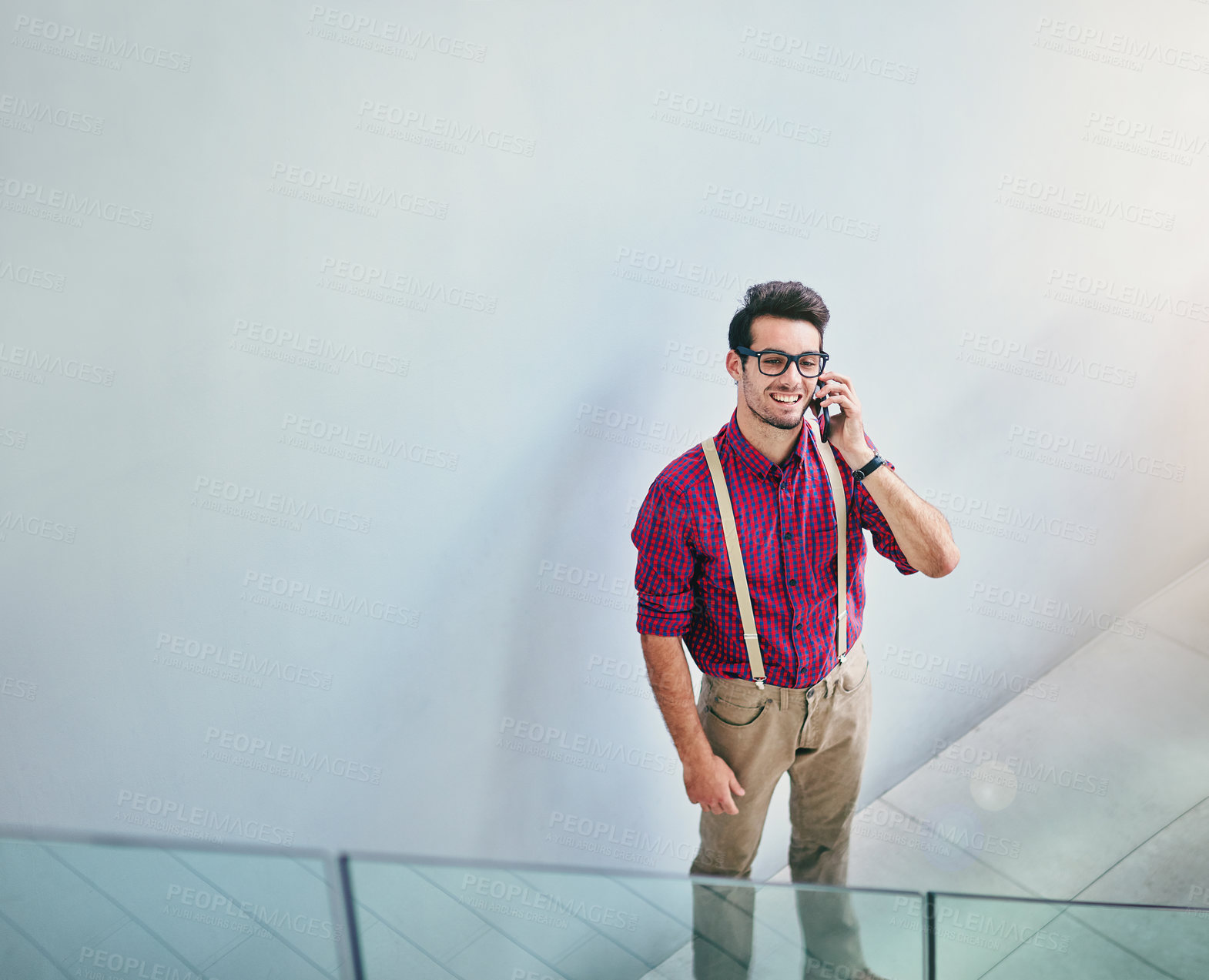 Buy stock photo High angle shot of a handsome young designer talking on his cellphone in the office