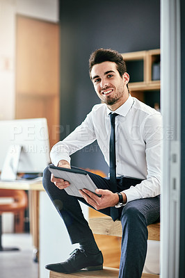 Buy stock photo Portrait of a trendy young businessman using his tablet while sitting on the stairs in his office
