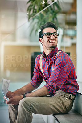 Buy stock photo Cropped shot of a handsome young designer holding paperwork in his office