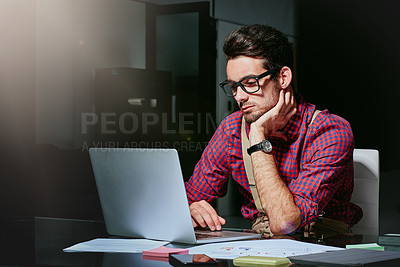 Buy stock photo Cropped shot of a handsome young designer working on his laptop in the office