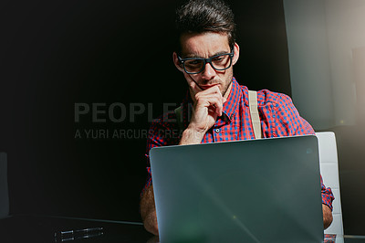 Buy stock photo Cropped shot of a handsome young designer working on his laptop in the office