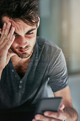 Buy stock photo Cropped shot of a beaten and bruised young man reading a text message