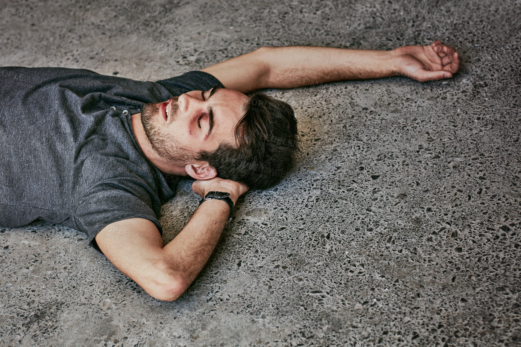 Buy stock photo High angle shot of a beaten and bruised young man passed out on the floor