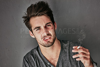 Buy stock photo Cropped portrait of a beaten and bruised young man smoking a cigarette