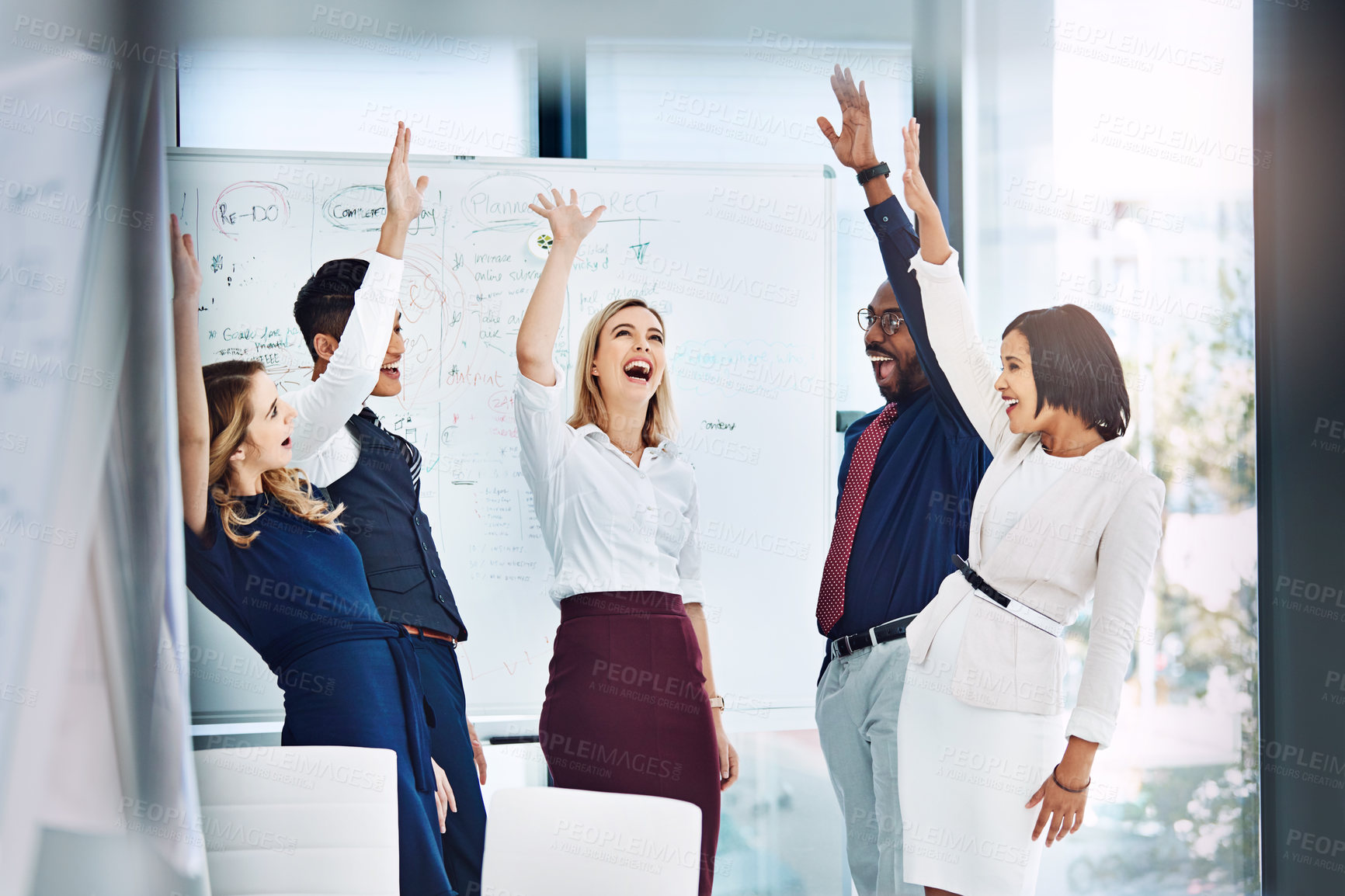 Buy stock photo Shot of a group of businesspeople standing with their arms raised in the office