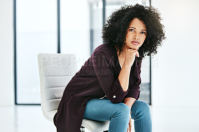 Buy stock photo Portrait of a confident young woman sitting on a chair at work in a modern office