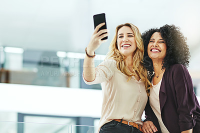 Buy stock photo Happy, smiling and cheerful women taking selfies with a phone while bonding, having fun and being carefree at work. Diverse, joyful and positive colleagues taking photos for social media