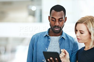 Buy stock photo Business people talking together while checking information, data or statistics on a tablet. Employee asking manager, supervisor or boss for help with a problem, project or idea while standing inside