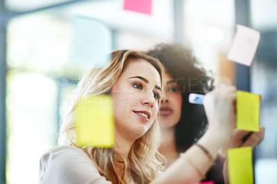 Buy stock photo Manager brainstorming, planning and writing sticky notes on glass window. Female worker showing corporate leadership, and management skills. Detail information on tasks to meet company objectives