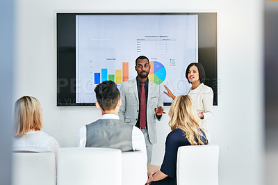 Buy stock photo Shot of a businessman and businesswoman giving a presentation to their colleagues at work