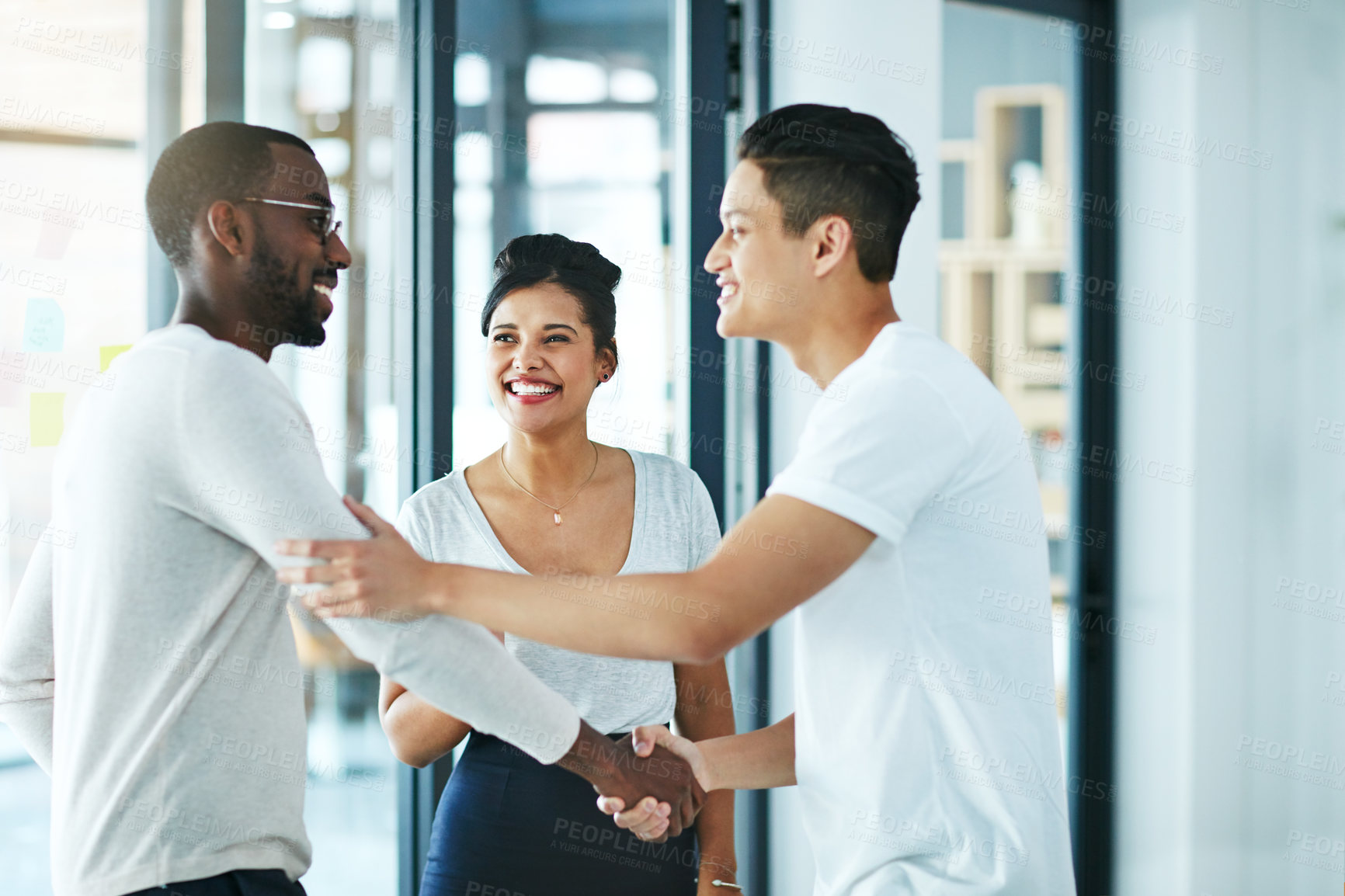 Buy stock photo Handshake, teamwork and agreement of business people greeting in an office or working together. Group or team of young colleagues talking, smiling and happy about success, a deal or promotion at work