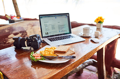 Buy stock photo Shot of a laptop and freshly made breakfast on a table outside