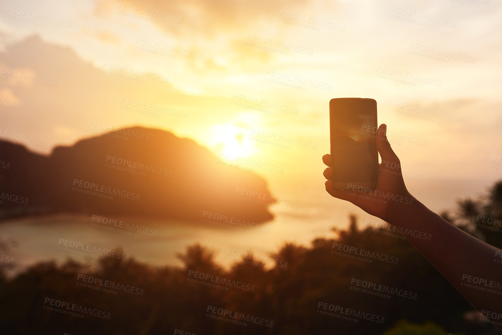 Buy stock photo Cropped shot of an unidentifiable tourist using a smartphone to photograph an island view