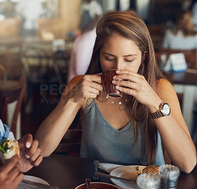 Buy stock photo Cropped shot of a young woman enjoying a cup of coffee in a cafe