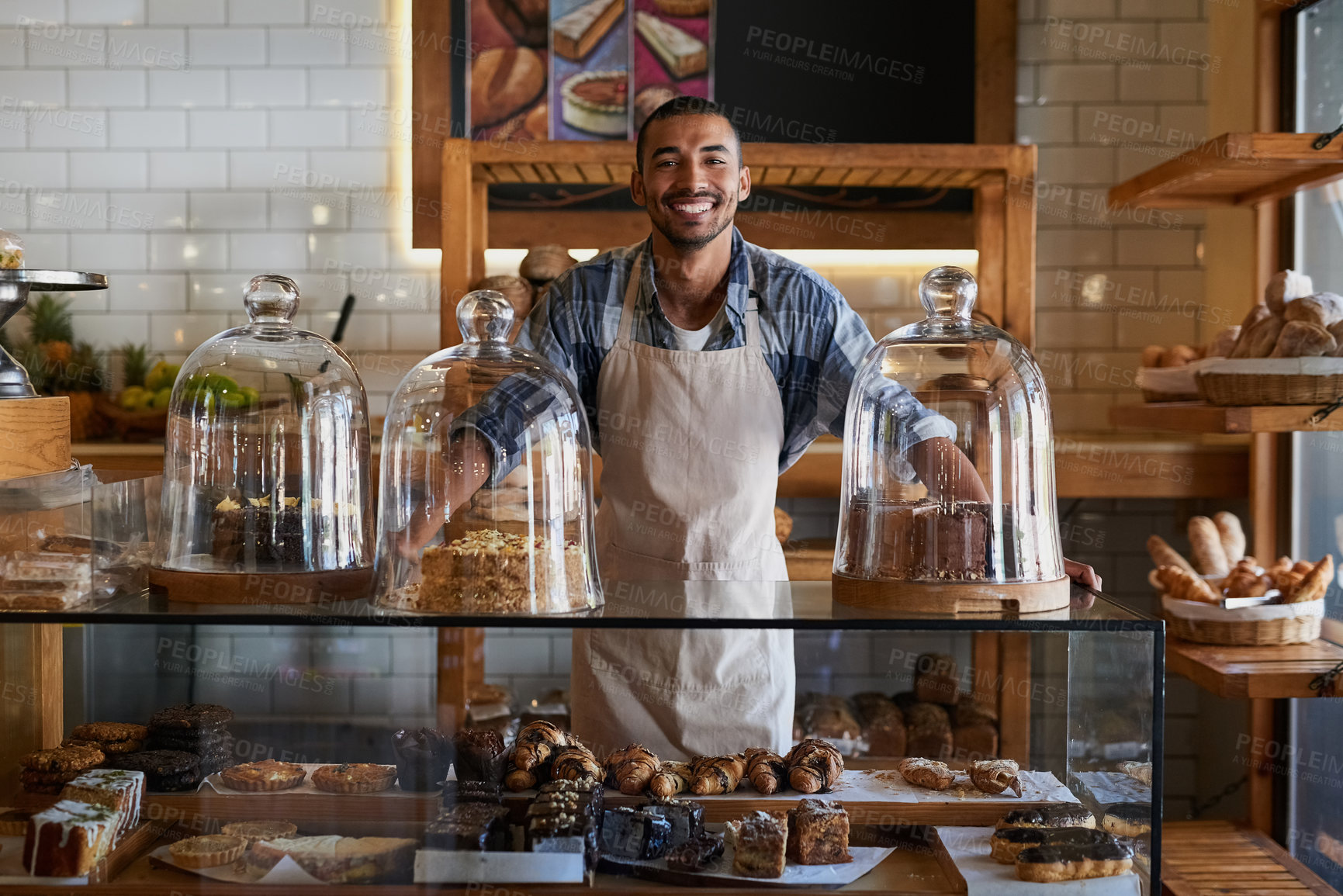 Buy stock photo Portrait of a young business owner standing behind the counter of his bakery