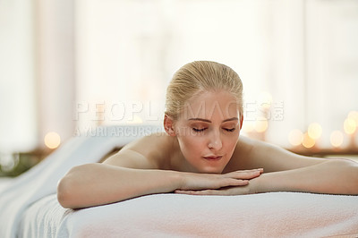 Buy stock photo Cropped shot of a young woman relaxing on a massage table at a spa
