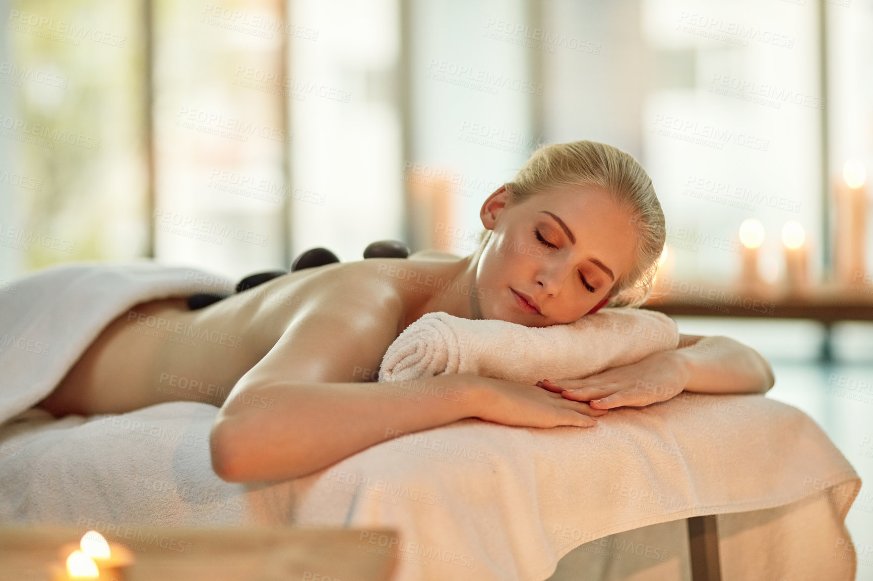 Buy stock photo Cropped shot of a young woman enjoying a hot stone massage at a spa