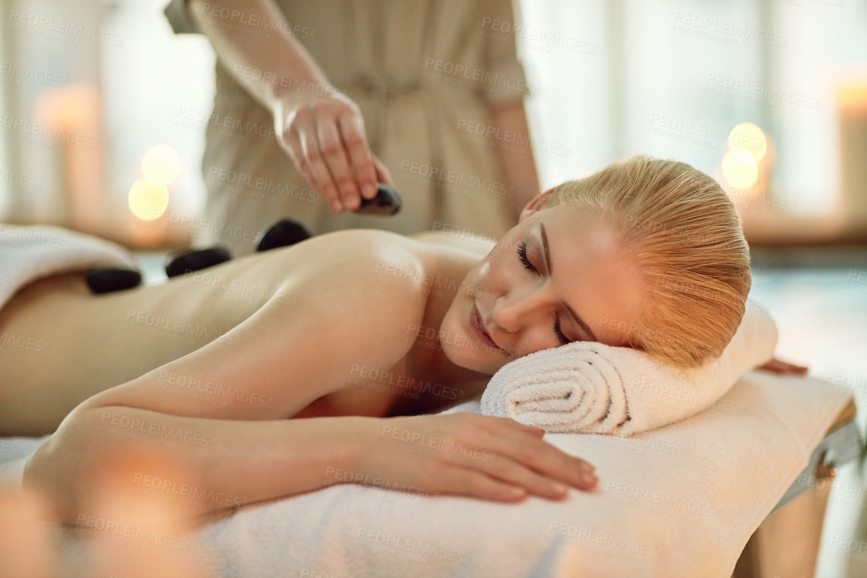 Buy stock photo Cropped shot of a young woman enjoying a hot stone massage at a spa