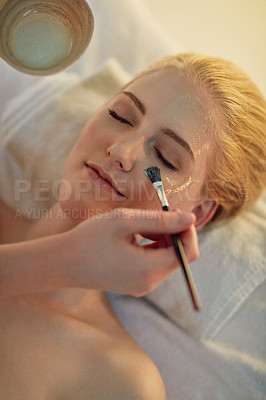 Buy stock photo Brush, woman and face mask at spa for health, wellness or cosmetics to relax for hospitality at resort. Masseuse, hands and dermatology treatment for antiaging therapy, healing or skincare beauty