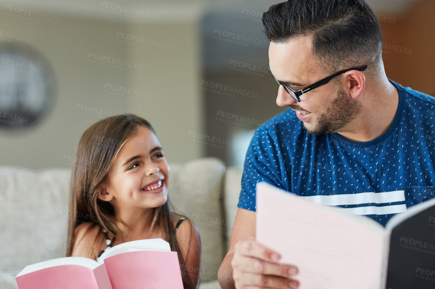 Buy stock photo Cropped shot of a father an daughter reading together at home