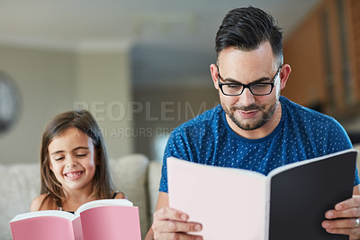 Buy stock photo Cropped shot of a father an daughter reading together at home