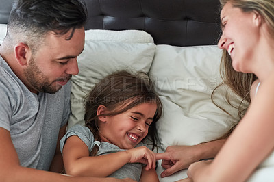 Buy stock photo Cropped shot of a family having fun while lying in bed at home