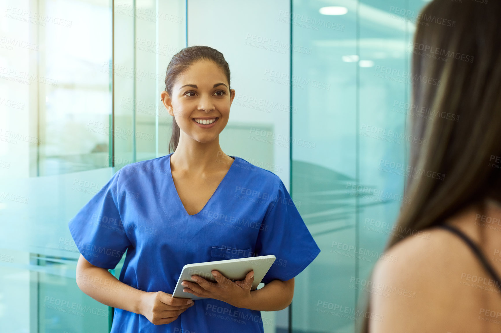 Buy stock photo Shot of a friendly young nurse greeting a patient in the clinic