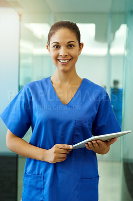 Buy stock photo Portrait of a young nurse using a tablet while standing inside a clinic