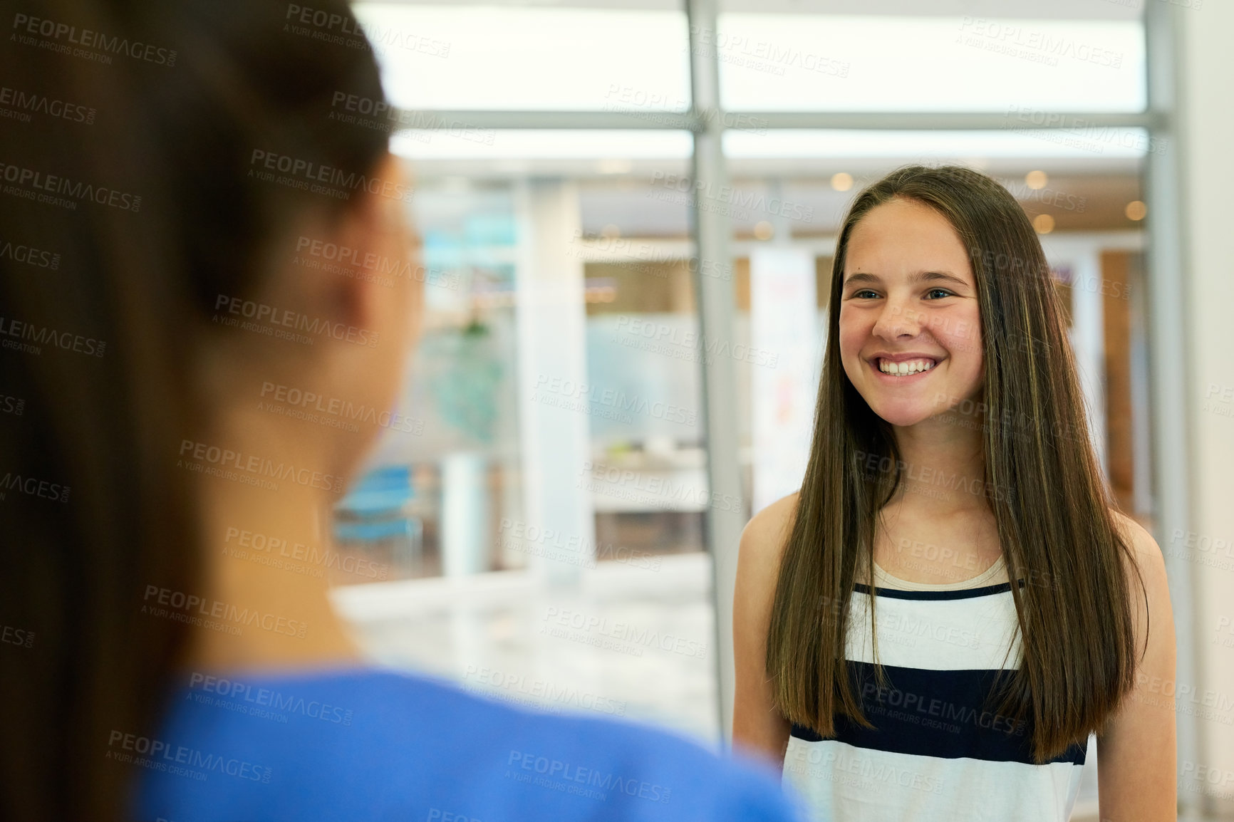 Buy stock photo Rearview shot of a nurse greeting a young patient in the clinic