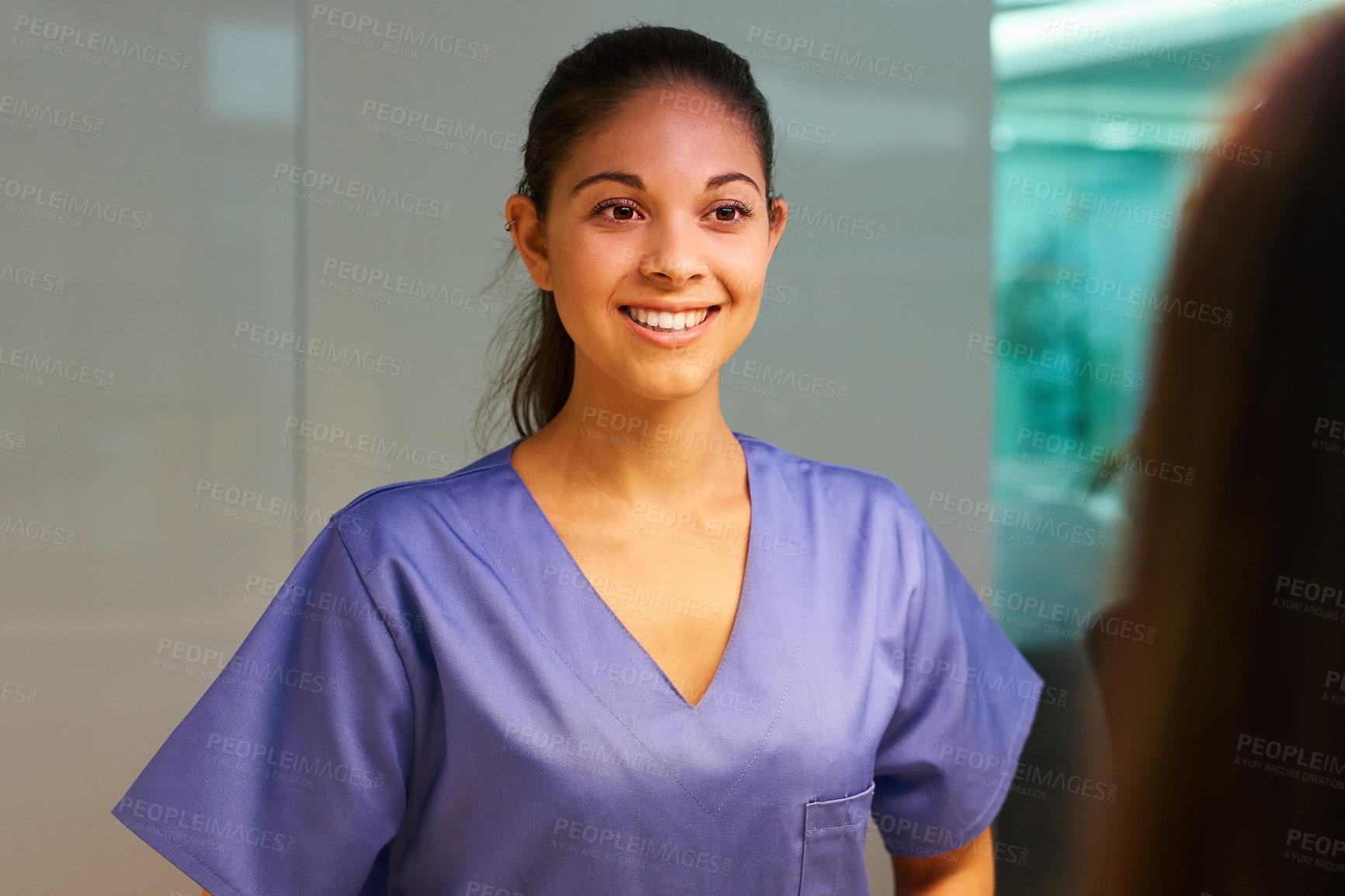 Buy stock photo Rearview shot of a young nurse greeting a patient in the clinic